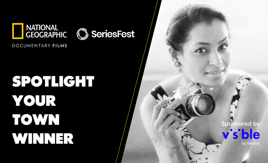 Alongside logos for National Geographic Documentary Films, SeriesFest, and Visible [mobile] by Verizon, this image is in black and white with white text that reads SPOTLIGHT YOUR TOWN WINNER in blocky white text. The right half of the image is a black and white portrait of an Asian woman named A.K. Sandhu, holding a film photography camera and wearing a white and black floral dress with her hair pulled back.